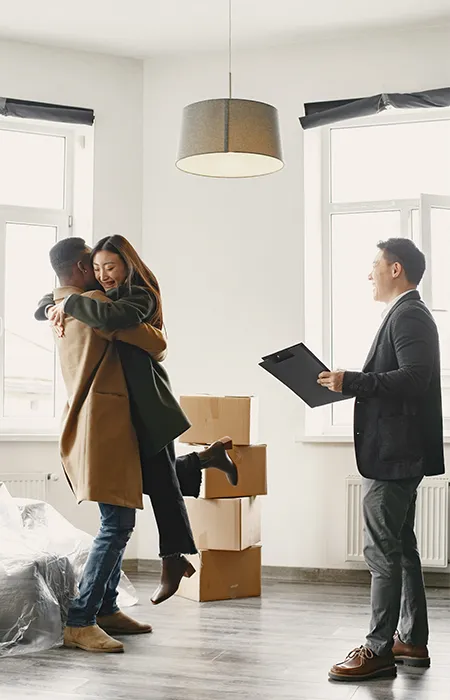 real estate agent and happy clients in a clean house